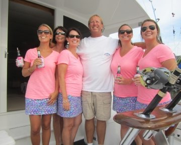 Women take a picture with the captain on boat